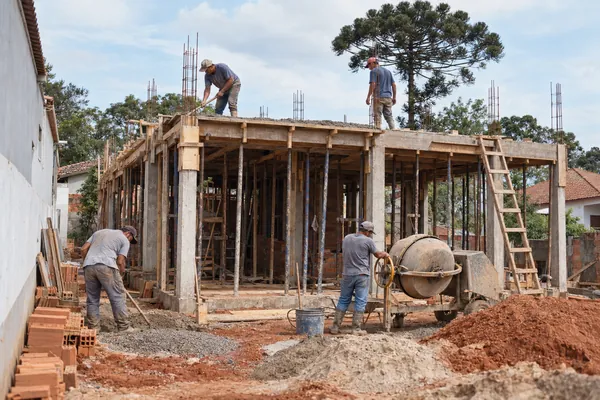 Concrete columns and beams with wooden formwork and props holding up the freshly poured slab.