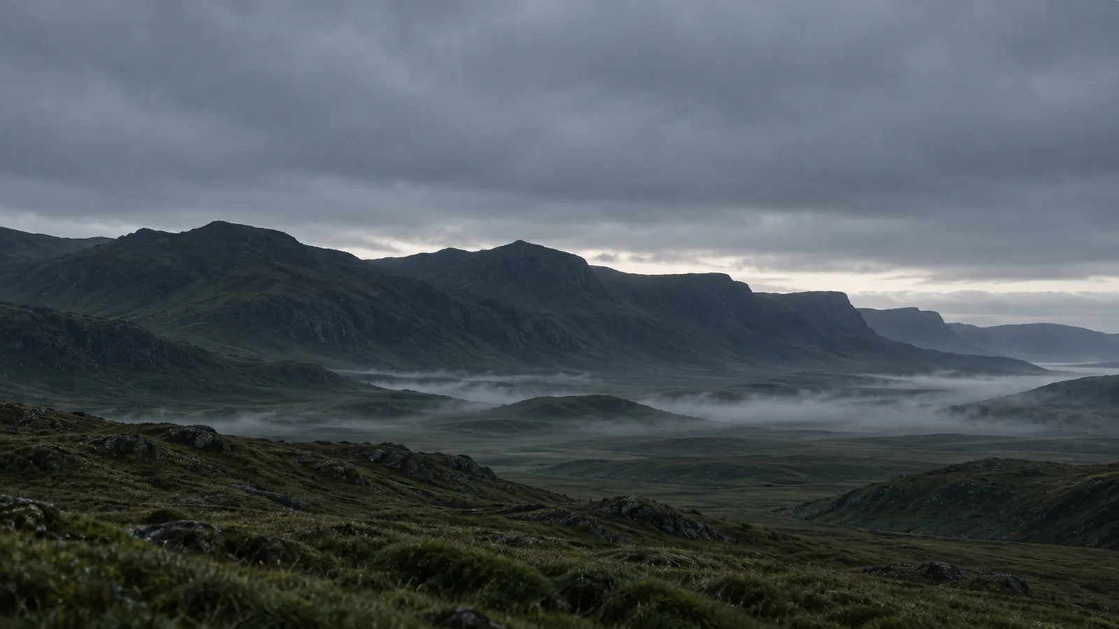 First light behind a long ridge, mist in the valley