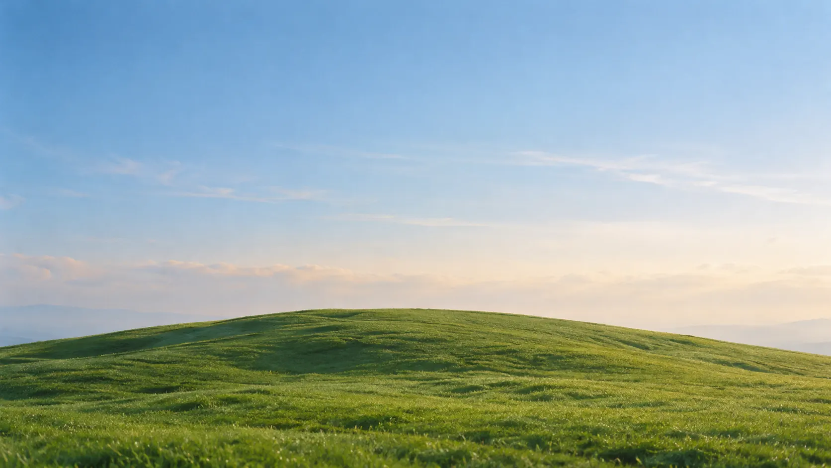 A long green hill ridge under a pale sky