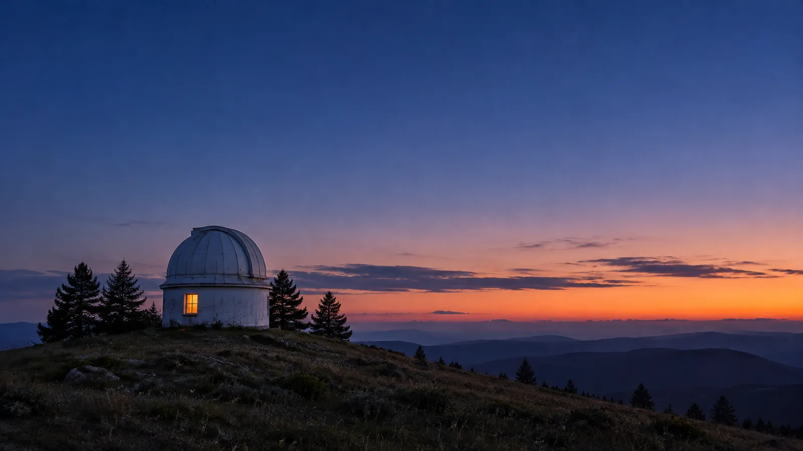 A small white observatory on a hilltop at blue hour, one window lit